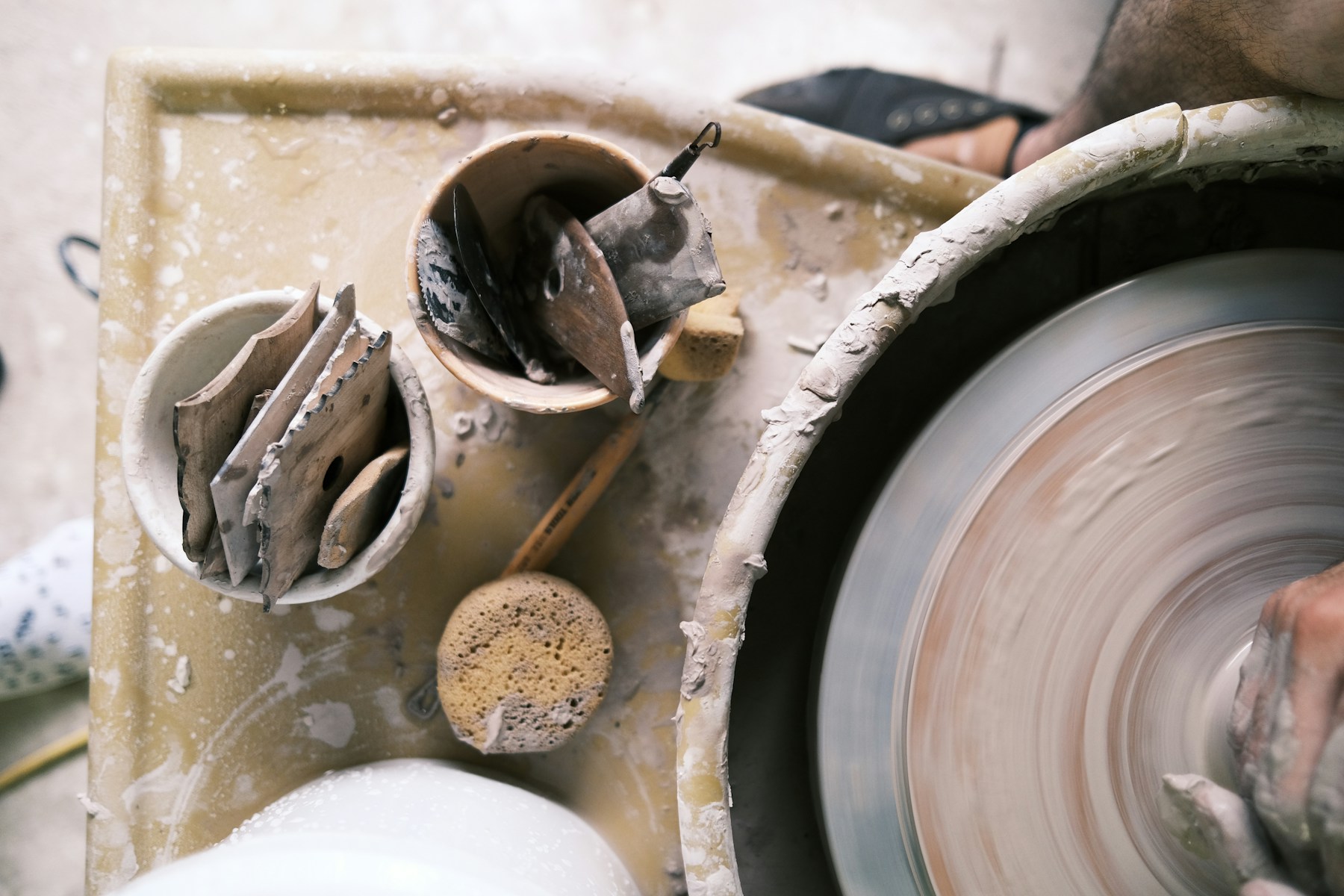 An artisan shaping clay on a pottery wheel